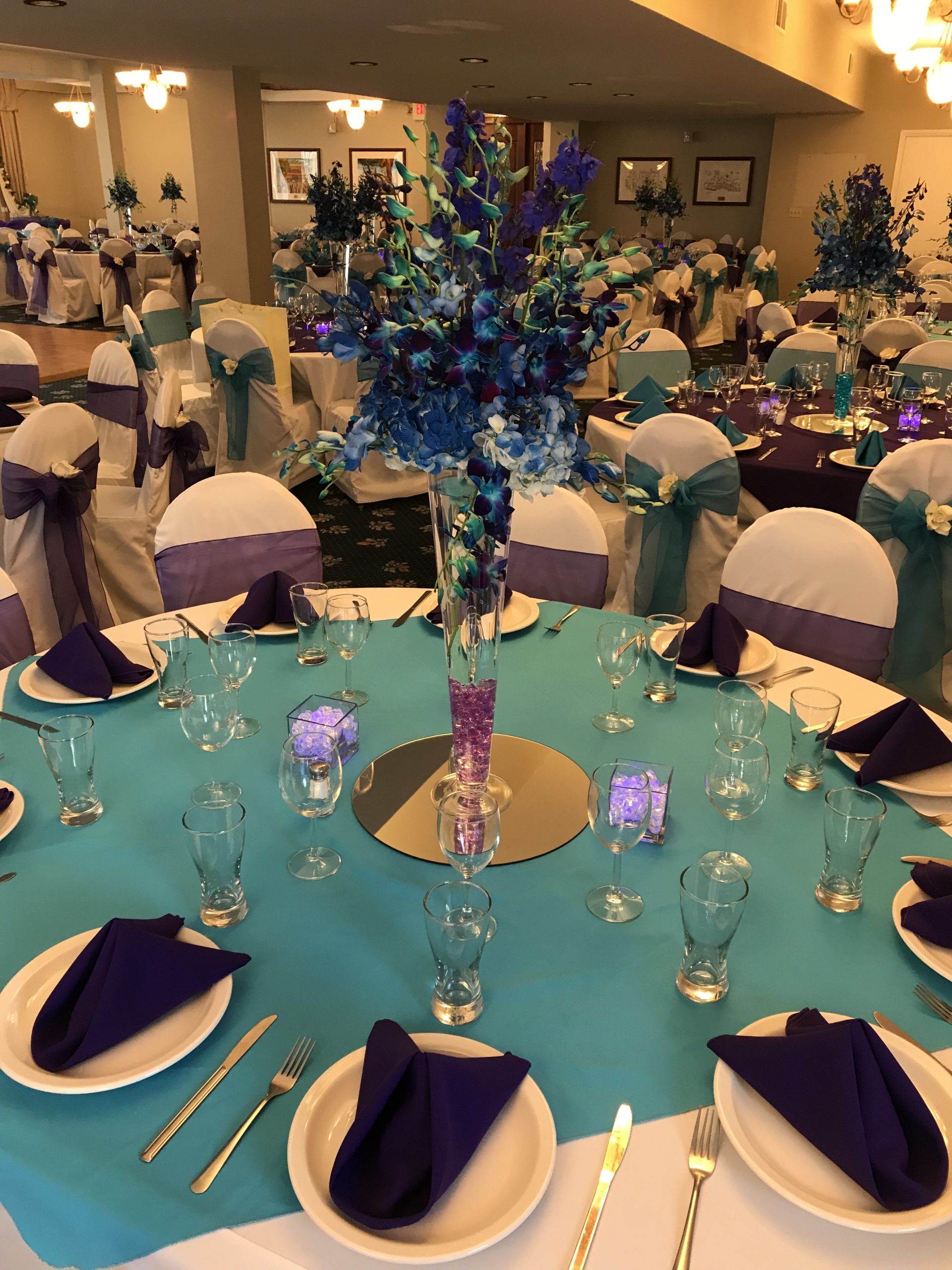 Banquet tables with turquoise linens and purple accents at Fiddlers Green